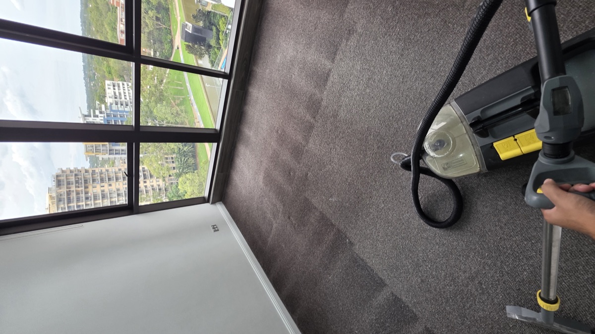 Carpet steam cleaning in progress in bedroom with city views