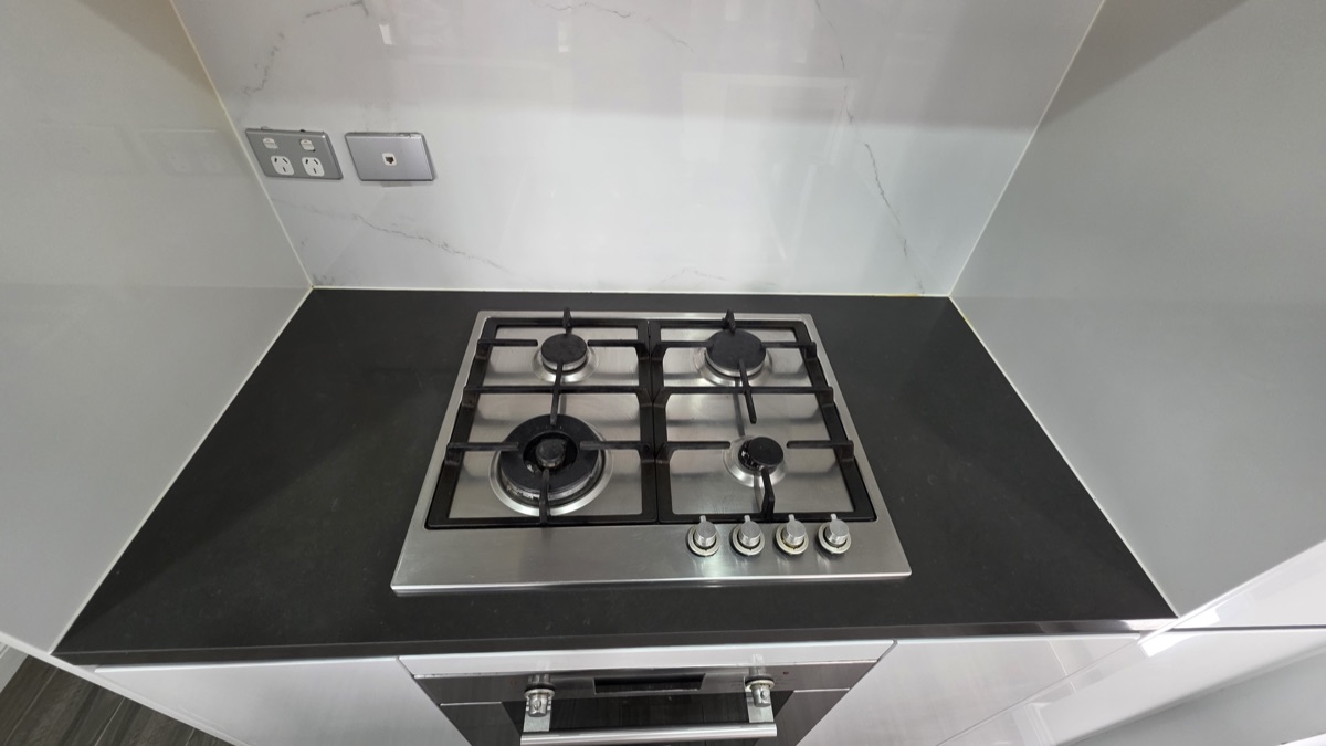 Gas cooktop with marble splashback and oven below cleaned to agent standard